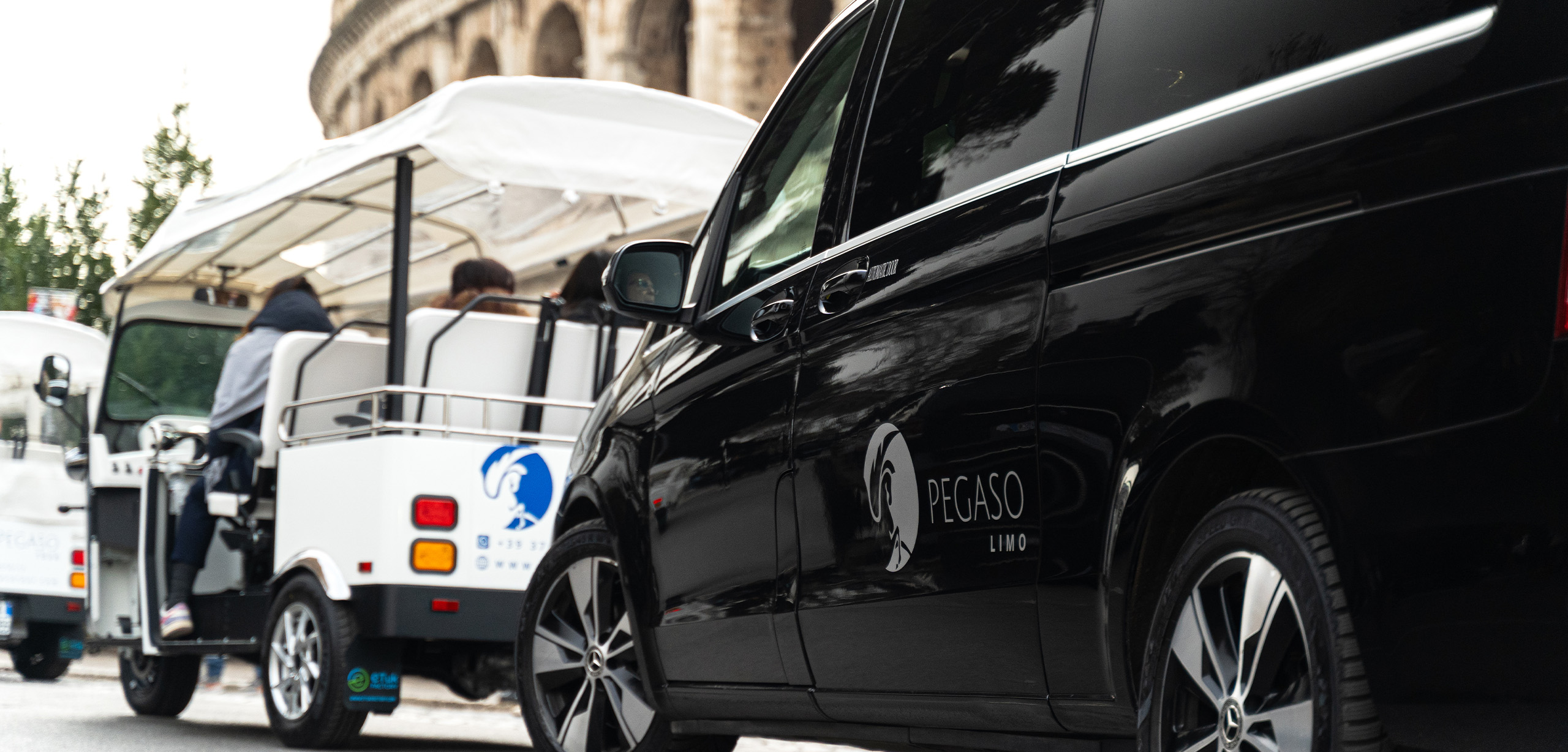 Pegaso electric tuk tuk and Pegaso Limo black van in front of the Colosseum